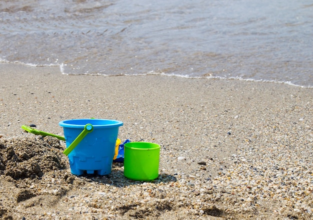 Giocattoli per bambini su una spiaggia di sabbia sulla spiaggia. vacanza con bambino al mare nei paesi del sud