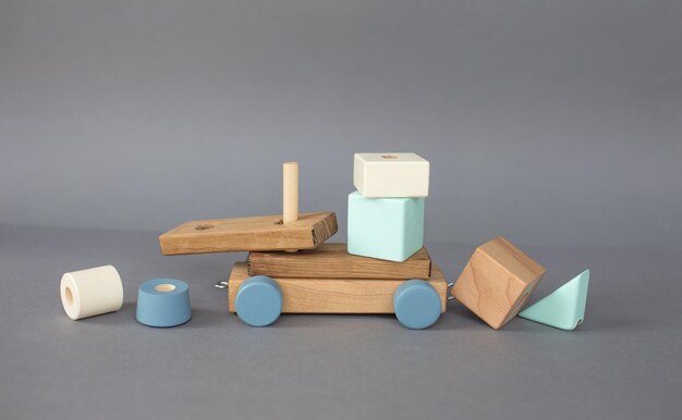 Children's wooden ecological handmade toys on wheels on a gray background