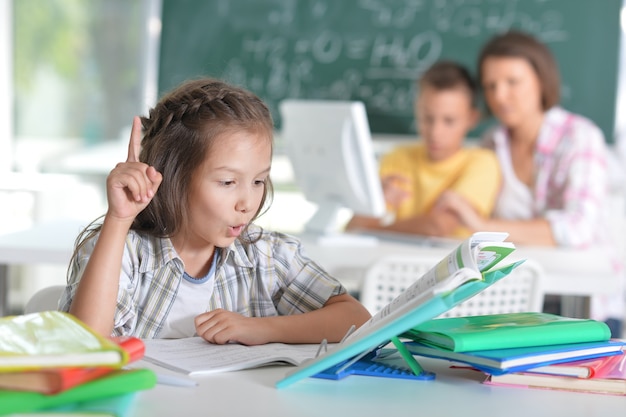 学校の子供たちは先生と一緒に教室に座っています