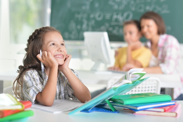 Children at school sit in the classroom with teacher