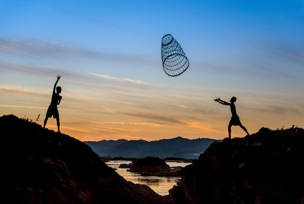 Photo children sharing tool for fishing in the sunset.