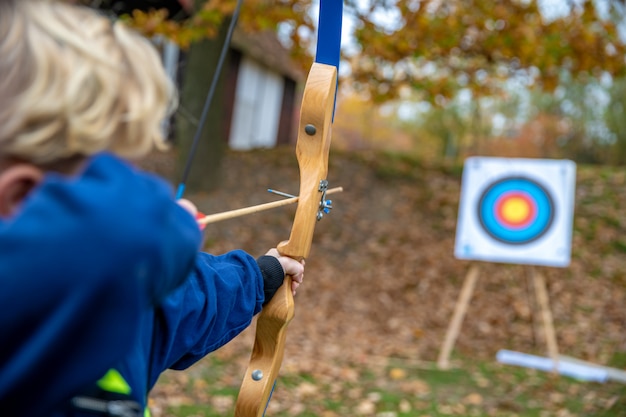 Children shot on target during a competition in archery in the forest