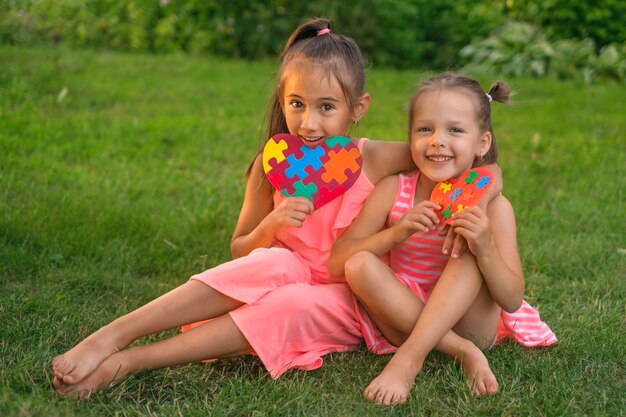 Children show their heartshaped postcards decorated with colored puzzles