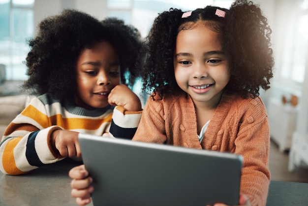 Children sisters and girls smile with tablet in home playing games and bonding together Technology family and happy mixed race kids with touchscreen for elearning streaming movie and video