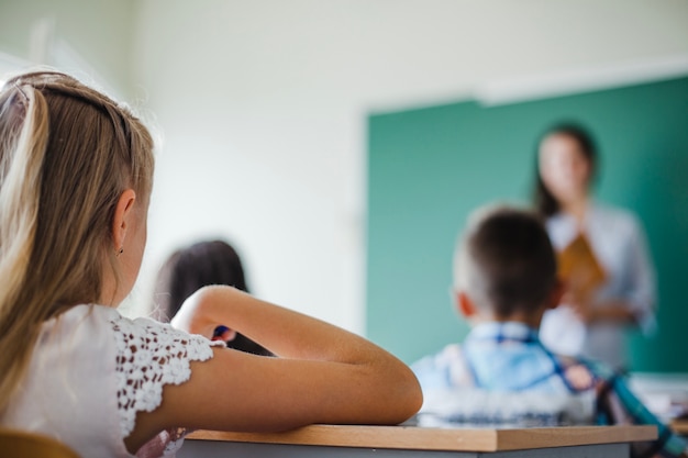 Foto bambini seduti in classe con insegnante