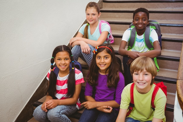 Photo children sitting on stairs in school