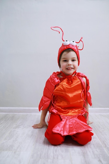 Children in smart carnival costumes on a plain background. Costume of sea fairy creatures. Mermaid and crab. Brother and sister.