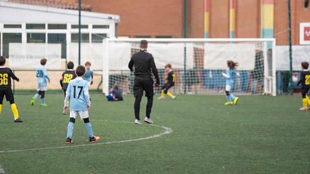 Children soccer team league match Attack and defensive action move while referee watch with attention