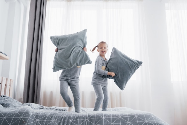 Children in soft warm pajamas playing in bed