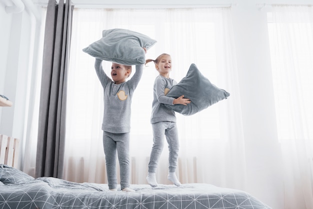 Children in soft warm pajamas playing in bed