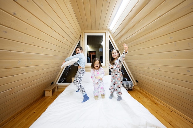 木製の小屋の家で遊んでいる柔らかい暖かいパジャマの子供たち 幼年期の余暇活動の幸福の概念 兄と妹が楽しんで一緒に遊んでいます