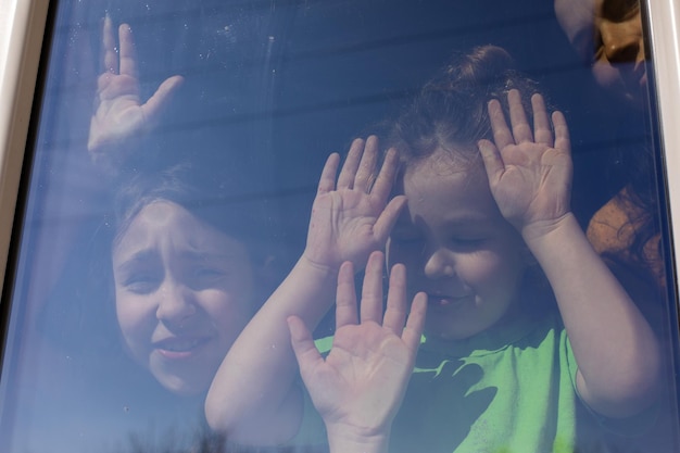 The children stay near the window and enjoy the weather