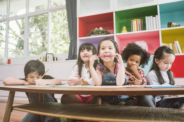 Photo children studying while sitting in school