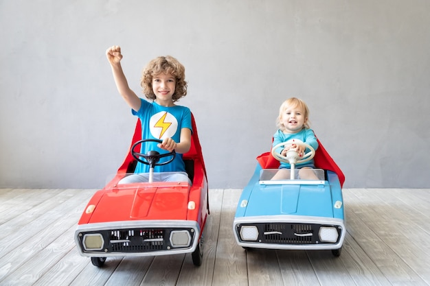 Children superheroes playing at home