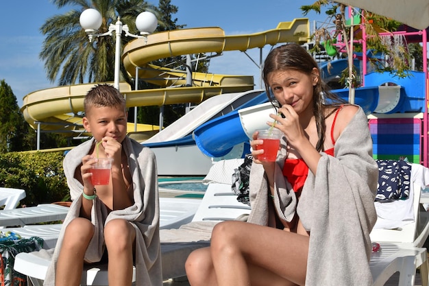 子供たちはウォーターパークの外のプールで泳ぎます。陽気な子供たちの夏のアクティブなウォータースポーツ。海での子供の休日