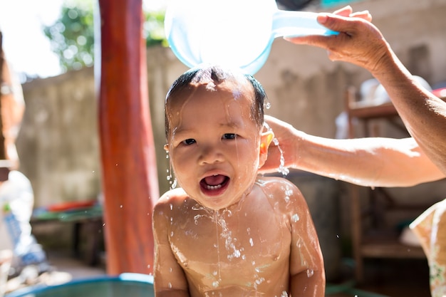 The children take a bath by parent.