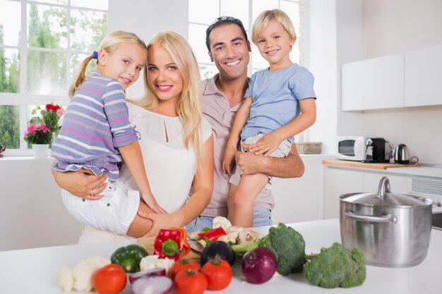 Children in their parents arms in the kitchen