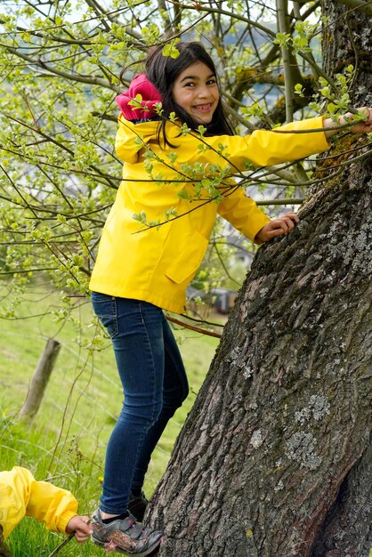 Photo children trying to climb a tree