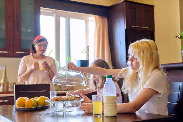 Children two sisters eating at home in the kitchen