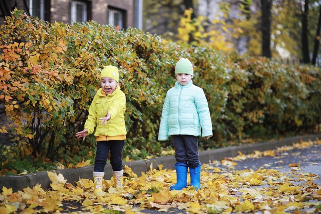 Children walk in the autumn park in the fall