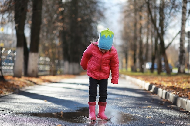 I bambini camminano nel parco autunnale in autunno