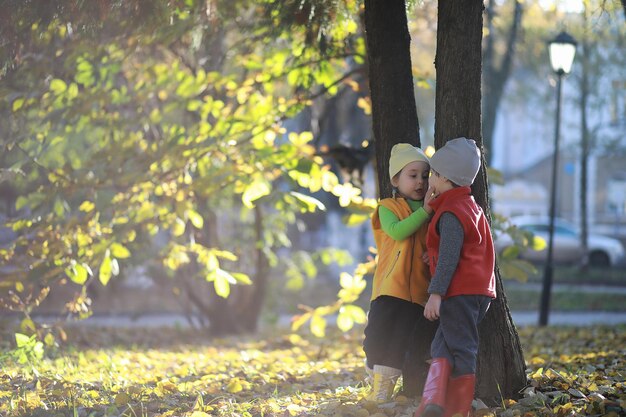 Children walk in the autumn park in the fall