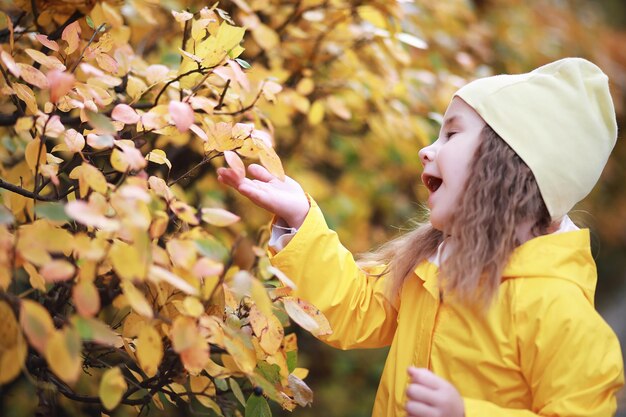 Children walk in the autumn park in the fall