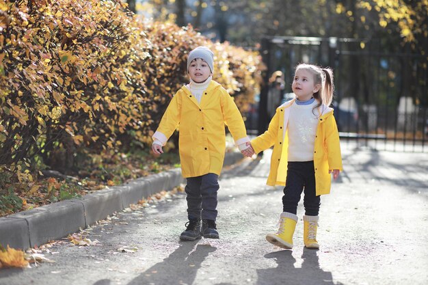 I bambini camminano nel parco autunnale in autunno