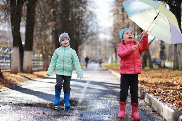 Children walk in the autumn park in the fall