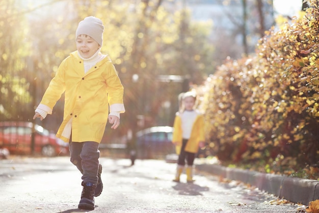 Children walk in the autumn park in the fall