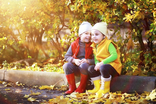 Children walk in the autumn park in the fall