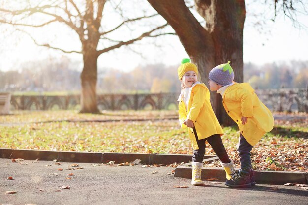 Children walk in the autumn park in the fall