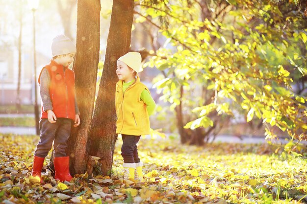 Children walk in the autumn park in the fall