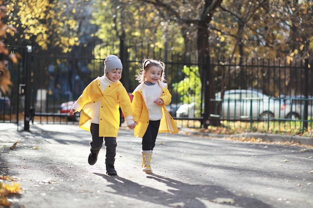 I bambini camminano nel parco autunnale in autunno