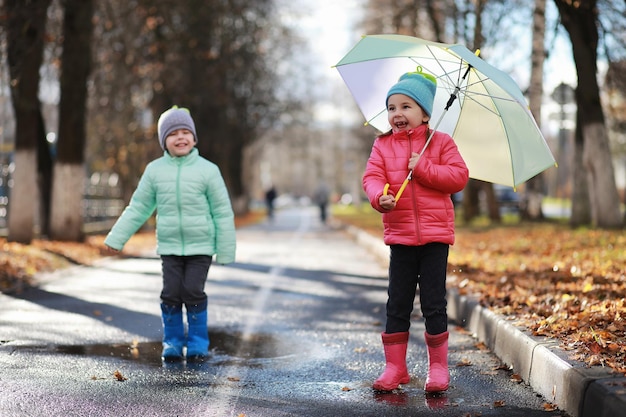 Children walk in the autumn park in the fall