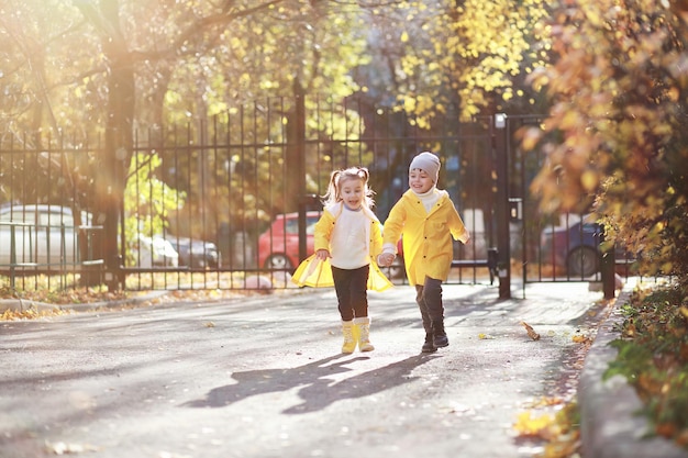 I bambini camminano nel parco autunnale in autunno