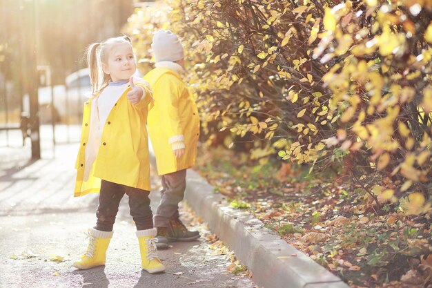 Children walk in the autumn park in the fallxA