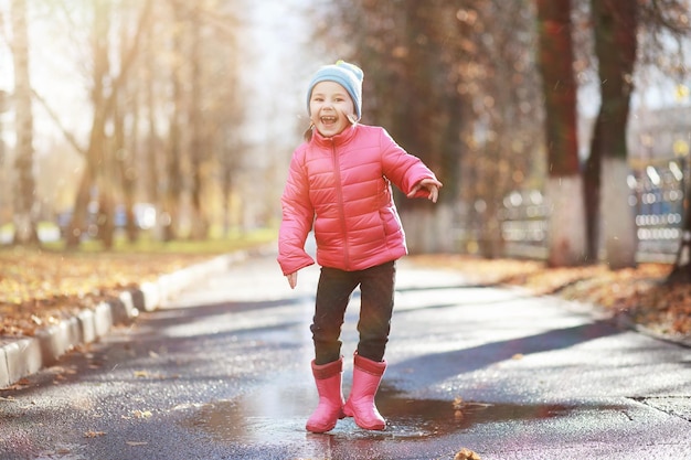 Children walk in the autumn park in the fallxA