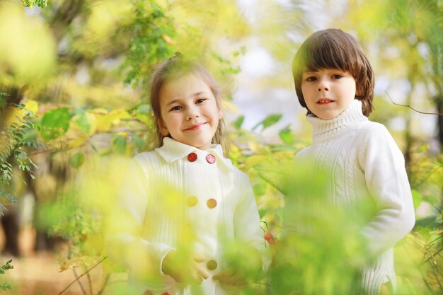 Bambini per una passeggiata nel parco autunnale. caduta delle foglie nel parco. famiglia. autunno. felicità.