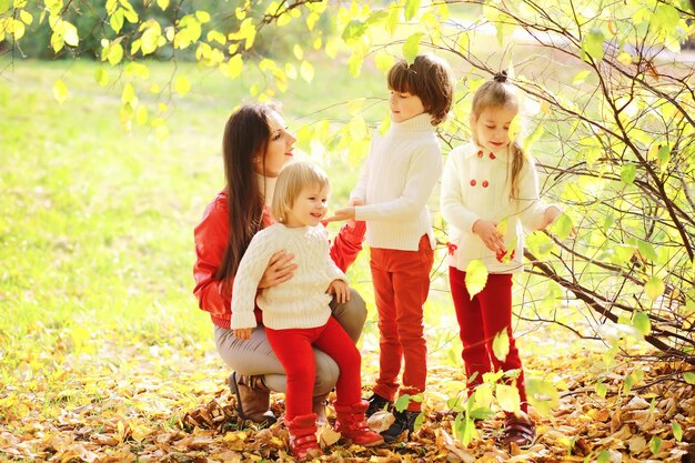 Foto bambini per una passeggiata nel parco autunnale. caduta delle foglie nel parco. famiglia. autunno. felicità.