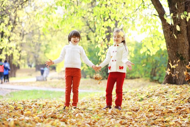 Children for a walk in the autumn park Leaf fall in the park Family Fall Happiness