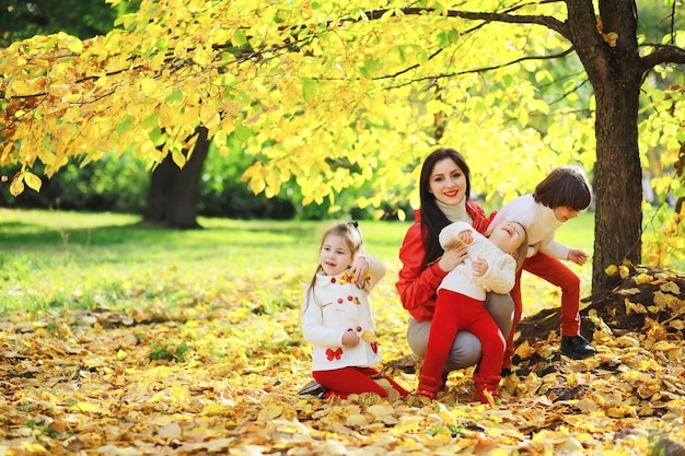 Children for a walk in the autumn park Leaf fall in the park Family Fall Happiness