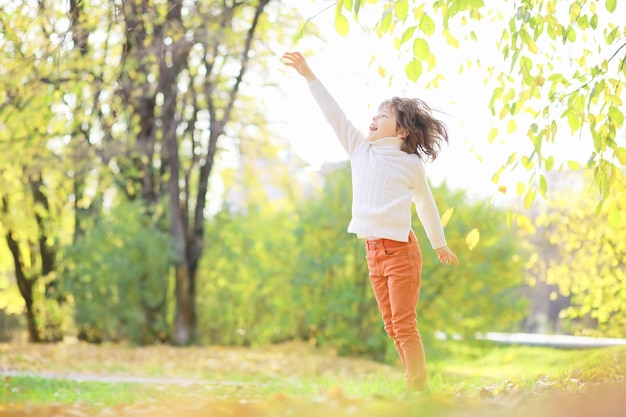 Children for a walk in the autumn park Leaf fall in the park Family Fall Happiness