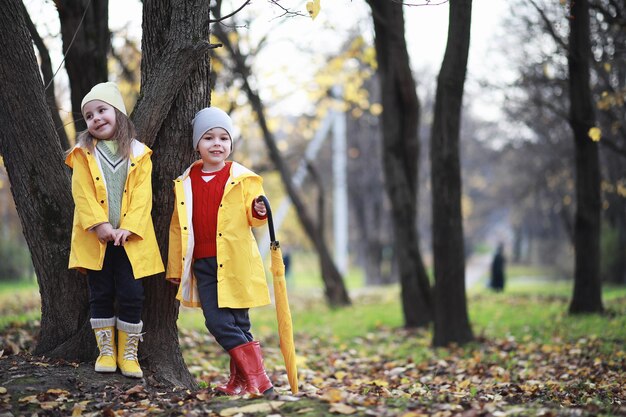 I bambini camminano nel parco autunnale