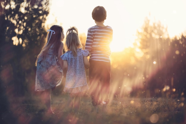 子供たちは自然の中で夏を歩く晴れた春の朝の子供公園で子供たちと一緒に旅行