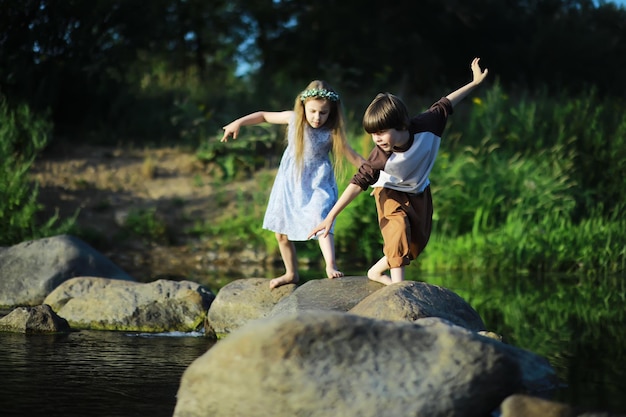 I bambini camminano in estate nella natura bambino in una soleggiata mattina di primavera nel parco viaggiare con i bambini