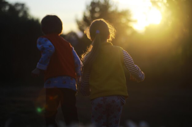 子供たちは自然の中で夏を歩く晴れた春の朝の子供公園で子供たちと一緒に旅行