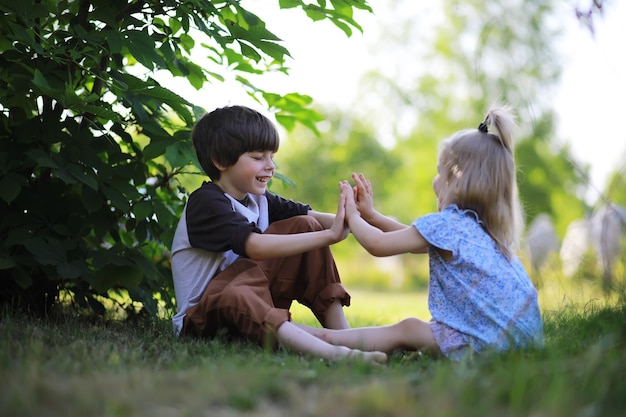 子供たちは自然の中で夏を歩く晴れた春の朝の子供公園で子供たちと一緒に旅行