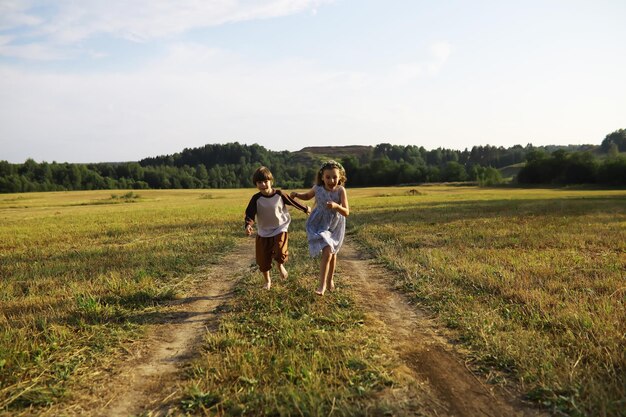 子供たちは自然の中で夏を歩く晴れた春の朝の子供公園で子供たちと一緒に旅行