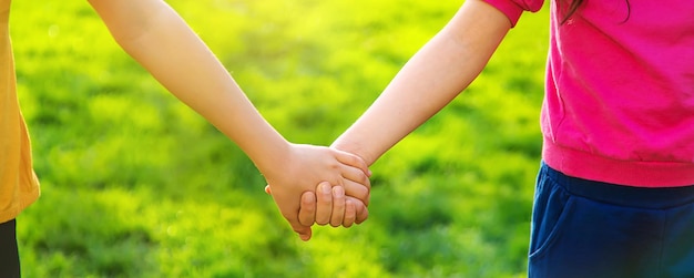 Foto i bambini camminano insieme tenendosi per mano messa a fuoco selettiva